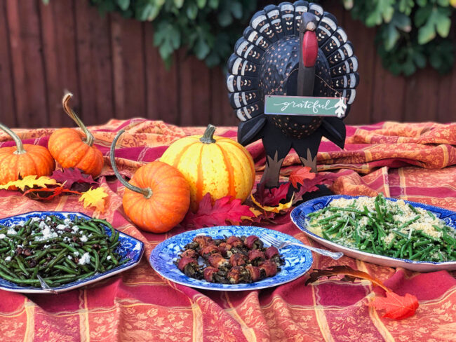 green bean bacon bundles spread on a table with fall decorations