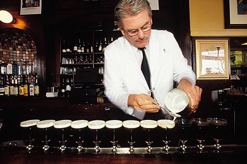 Bartender topping off whipped cream on Irish Coffee